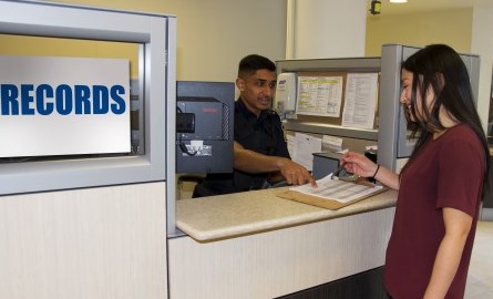 Woman and employee talking at records kiosk